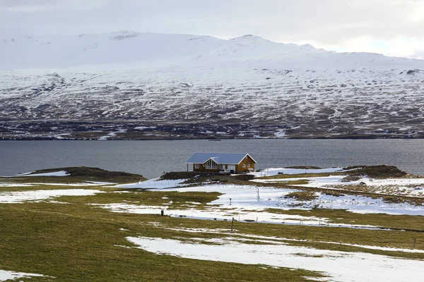 Okyanus kenarında karla kaplı görkemli dağlar. İzlanda Manzarası — Stok fotoğraf