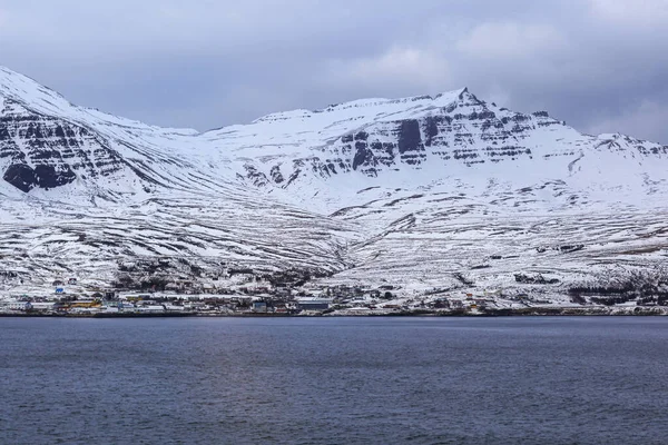 Terra e montanhas cobertas de neve, perto do oceano . — Fotografia de Stock