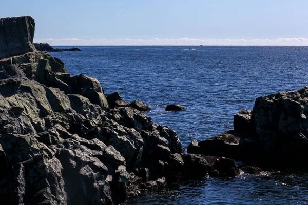 Roccia basaltica nell'oceano. Ondate di luce sull'acqua — Foto Stock