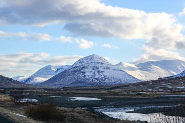 Kara ve dağlar karla kaplı, okyanus kenarında..