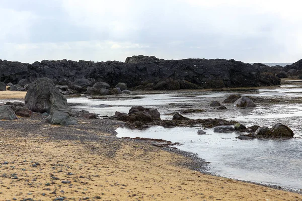 Bazaltowe skały na wybrzeżu błękitnego oceanu w Islandii. — Zdjęcie stockowe