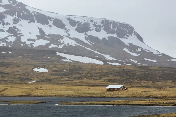 Prachtige bergen bedekt met sneeuw op de oceaan in IJsland. Regenachtig weer — Stockfoto