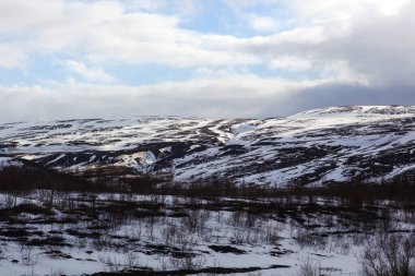 Kara ve dağlar karla kaplı, okyanus kenarında..
