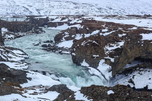 Schnell kochender Fluss in Island, zwischen Felsen und Schnee — Stockfoto