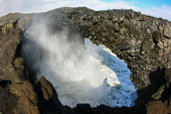 Onde oceaniche che si infrangono sulle rocce basaltiche costiere in Islanda. Spray marino — Foto Stock