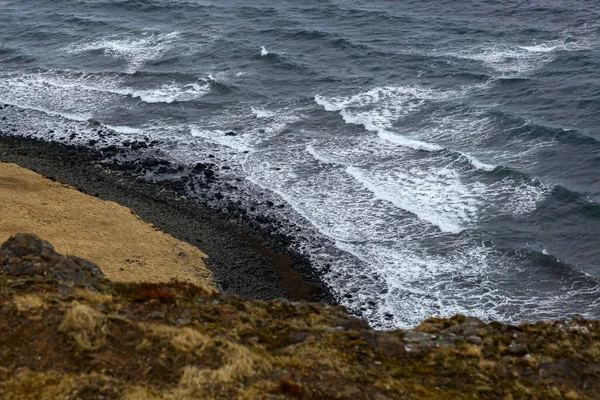 Pobřeží mezi oceánem a černou písečnou pláží na Islandu — Stock fotografie