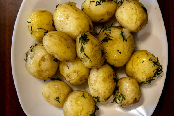 Las patatas jóvenes cocidas en la fuente. Delicioso almuerzo casero de verduras —  Fotos de Stock