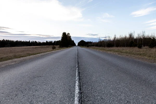 Bulutlu güzel gökyüzünün arka planında beyaz şeritli yol