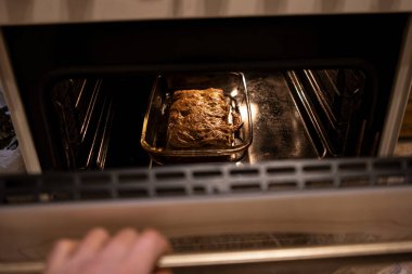 Lazanya fırında pişmiş durumda. Lezzetli bir ev yemeği pişiriyorum.