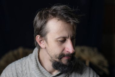 Sakallı genç bir adam süveter içinde buruşuk bir görünüme sahipti. Alkolizme karşı mücadele