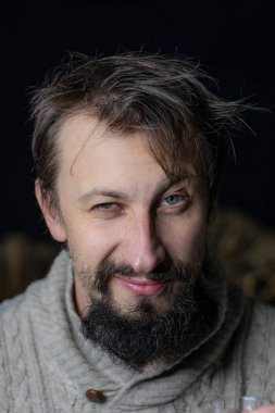 Sakallı genç bir adam süveter içinde buruşuk bir görünüme sahipti. Alkolizme karşı mücadele