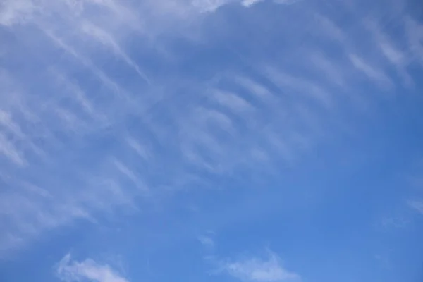 Hermosas rayas de nubes de pluma en un cielo azul. Fondo y textura claros — Foto de Stock
