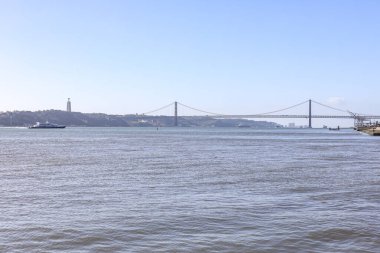 Portekiz 'de nehrin karşısındaki güzel demir haç. Lizbon 'da 25 Nisan Köprüsü