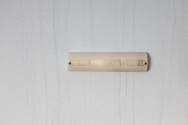 A lâmpada velha na parede com fluxos de líquido. Quarto de hotel sujo — Fotografia de Stock