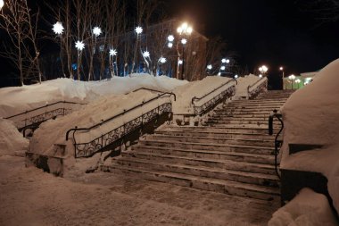 Işıklı karlı şehir merdiveni. Gece şehri manzarası