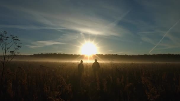 Koppel op de achtergrond van de zon. Slow-motion. Verticale pan. — Stockvideo