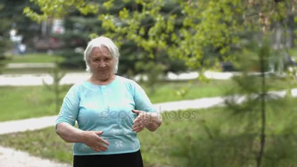 Retrato de uma avó fofa e alegre no parque . — Vídeo de Stock