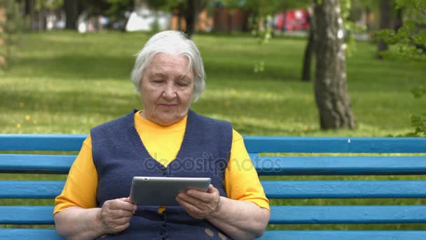 Бабушка пользуется планшетным компьютером. 2 шота . — стоковое видео