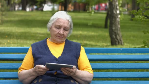 Die Großmutter nutzt einen Tablet-Computer. 2 Schüsse. — Stockvideo