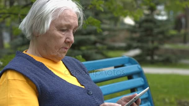 La abuela usa una tableta. 2 disparos . — Vídeo de stock