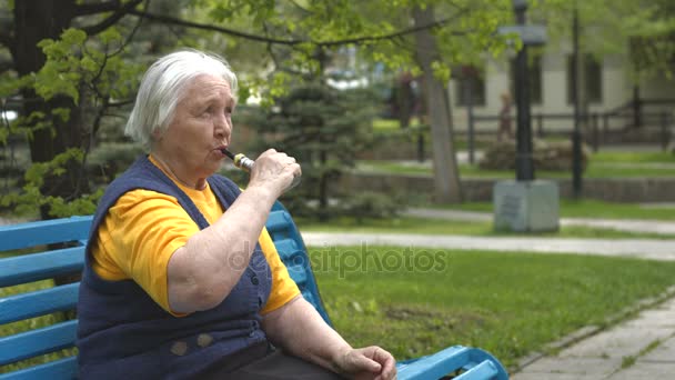 Mormor röker en elektronisk cigarett. Slow motion. — Stockvideo