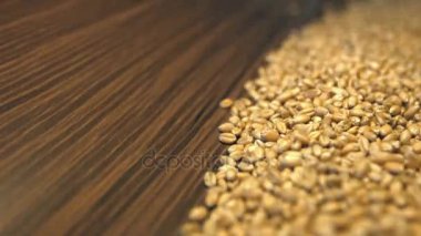 Buğday taneleri kahverengi ahşap arka plan üzerinde. 2 tekila. Yatay pan. Yakın çekim.