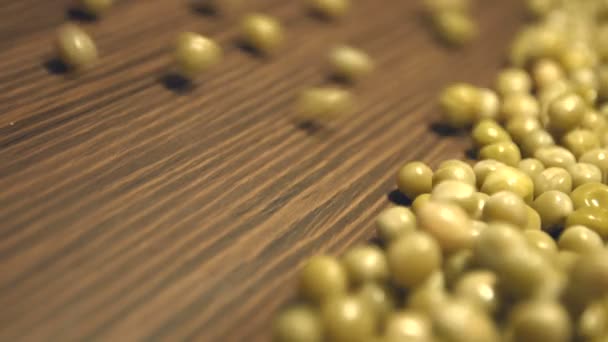 Pois verts en conserve sur fond de bois brun. 2 coups de feu. Poêle verticale. Gros plan 1. Pois verts en conserve roulent vers le bas (de gauche à droite) sur un fond en bois brun et remplit le cadre de tout l'espace.2. Panorama vertical (de haut en bas) .