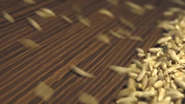 茶色の木製の背景にライ麦粒です ショット スローモーション 垂直方向のパン 閉じる ライ麦粒の茶色の木製の背景に 左から右へ から降ろすとすべてのスペース Frame を塗りつぶします — ストック動画