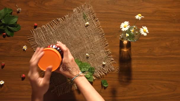 Aardbeien en een boeket van chamomiles op de tafel. Bovenaanzicht. — Stockvideo