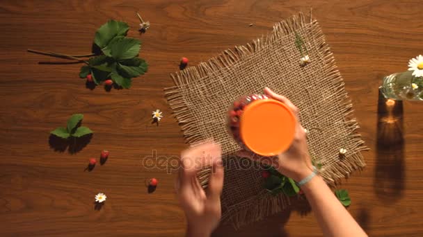 Fresas y un ramo de manzanillas sobre la mesa. Vista superior . — Vídeo de stock