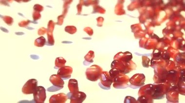 Beyaz zemin üzerine nar taneleri. 2 tekila. Ağır çekim.