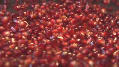 Kahverengi ahşap zemin üzerine nar taneleri. 2 tekila. Ağır çekim. Dikey pan. Yakın çekim.