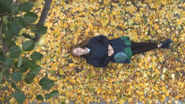 La chica entre las hojas amarillas . — Vídeo de stock