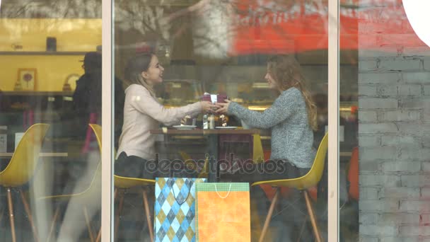 Девушки с подарком в кафе . — стоковое видео