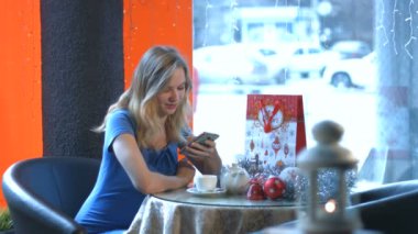 Bir kafede bir akıllı telefon ile kız.