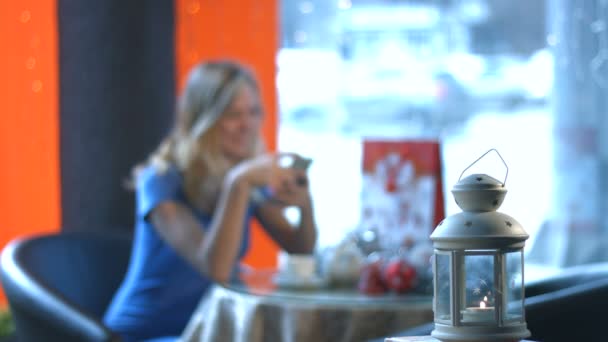 Chica con un smartphone en un café . — Vídeos de Stock