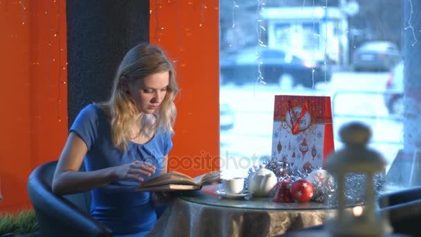 Fille avec un livre dans un café . — Video