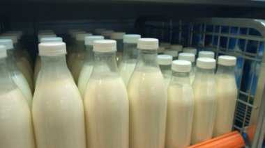 Şişe süt mağaza rafındaki. Kameranın süt şişesi olan raf hareket eder..