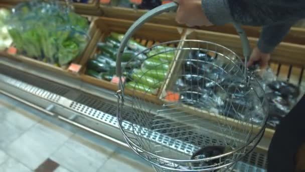 スーパーで野菜を買います スローモーション 男の手がバスケットにナス ズッキーニ キャベツ ジャガイモを置く — ストック動画