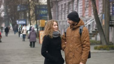 Genç bir çift bir şehir sokak üzerinde. Adam ve kız birlikte bir yaya Caddesi üzerinde duran ve neşeyle konuşuyor.