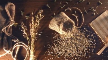 Üstten Görünüm. Erkek eller bir kase yulaf ezmesi gevreği masaya konur. (Soldan sağa) kamera masanın üzerine yumuşak kayma hangi yulaf, bir tabak yulaf ezmesi gevreği ve kır çiçekleri ile bir çantam.