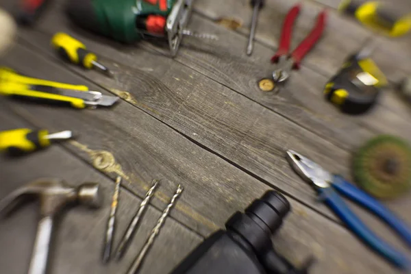 Tools on the table.On the table is: puncher, drills on concrete, hammer, screwdrivers, knife for paper, jigsaw, clippers, measuring tape, grinding disc, pliers.