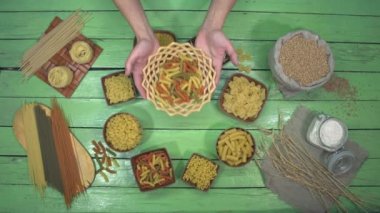 Makarna ve erişte çeşitleri. Üst Manzara. Göğüs göğüse yapılan bir makarnanın tanıtımı. Tanıtılan plakada renkli uzun spiraller (fusilli) görüyoruz. Yanında bir torba buğday ve un var..
