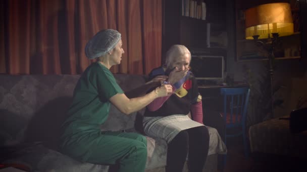 高齢者のためのケア 2ショット1 看護婦は祖母に水のマグカップを与える2 接近中だ 祖母は薬を水で洗い流して — ストック動画