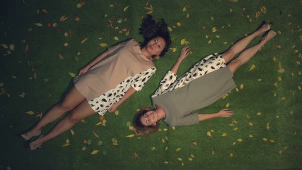 Twee Meisjes Het Gras Langzame Beweging Bovenaanzicht Aziatische Kaukasische Meisjes — Stockvideo