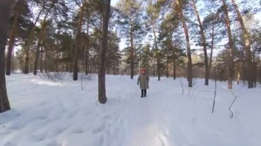 Büyükanne, kış ormanlarında huş ağaçları ve çam ağaçları arasında bir patika boyunca yürür. Kamera ona doğru hareket eder ve ondan uzaklaşır..