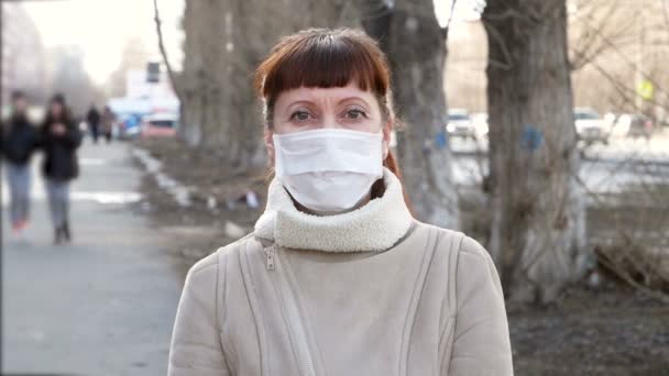 医療マスクの女 街の通りに女性の肖像画 彼女は彼女の保護医療マスクを脱ぐ — ストック動画