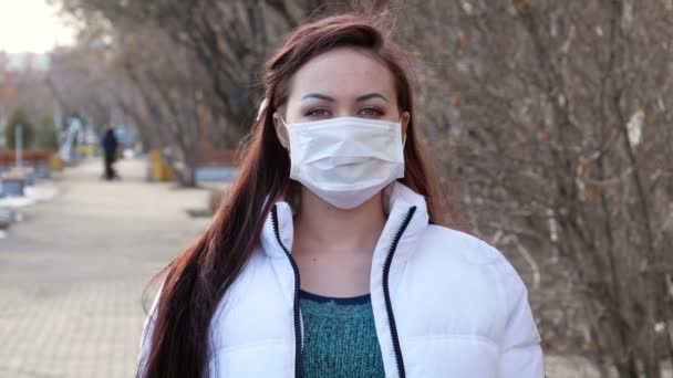 戴口罩的女孩一个女孩在城市街道上的肖像 她摘下防护口罩 — 图库视频影像