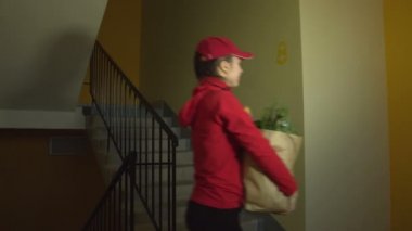 Kurye eve yiyecek getiriyor. 2 atış: 1. Yemek dağıtım servisindeki kız merdivenlerden 2. kata çıkıyor. Kurye kapıya gelir ve emri adama iletir. Poşetten sarkan bagetler, süt, otlar, muzlar..