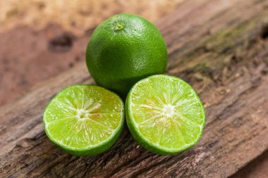 Yeşil limon - limon ve yarım limon narenciye meyve ahşap arka plan, Closeup çekim, Select odak ile.